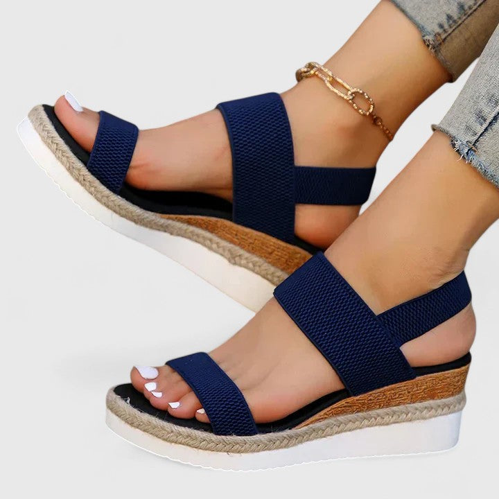 Navy orthopedic sandals with wide straps and tan espadrille sole, with gold chain ankle strap